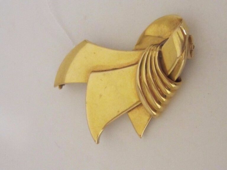 BROCHE « nœud stylisé » en or jaune (750 millièmes) godronné et ajouré à motifs de volute