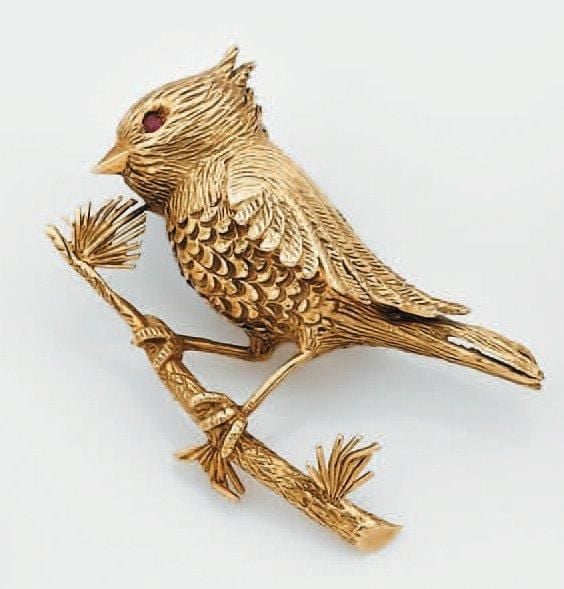 BROCHE «oiseau sur sa branche» en or jaune ciselé serti d'un rubis ron
