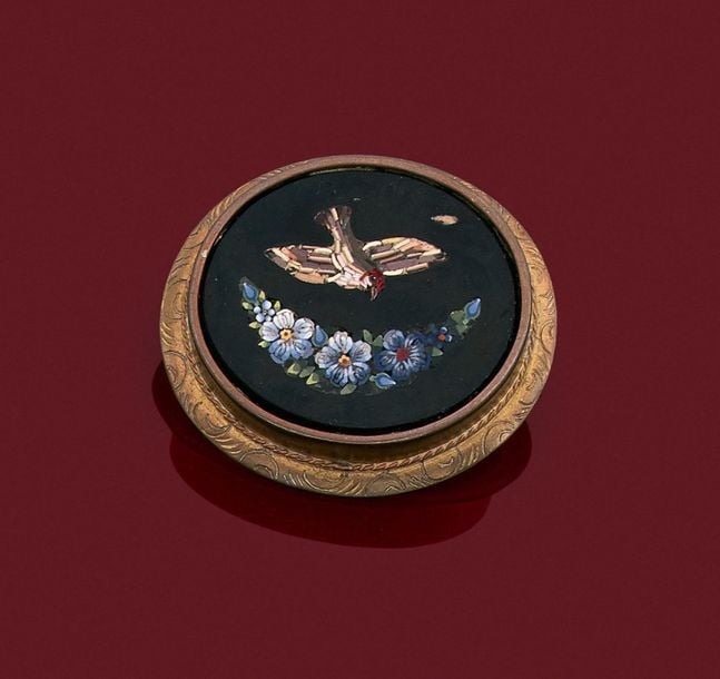 •BROCHE ovale en métal ciselé et torsadé serti d'une miniature en micro-mosaïque représentant un oiseau et une guirlande de fleur