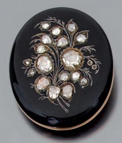 BROCHE ovale en or jaune 14 carats (585 millièmes) émaillé de noir, ciselé d'un bouquet de fleurs, et serti de dix-huit diamants dont deux plus important