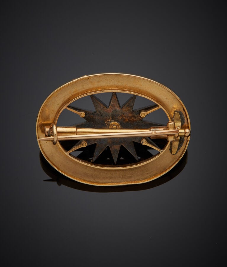 BROCHE ovale "étoile" en or jaune (750‰) et argent (min. 800‰) ajouré, centrée…