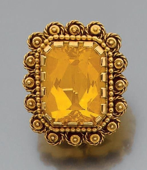 BROCHE rectangulaire en or jaune (750 millièmes) ciselé, boulé et torsadé à motifs de fleurettes stylisés, sertis d'une importante citrine taillée à degré