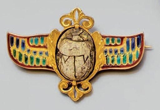 BROCHE «scarabée ailé» en or jaune ajouré et ciselé, orné d'une pierre dure gravée épaulée de deux ailes orné d'émail polychrom