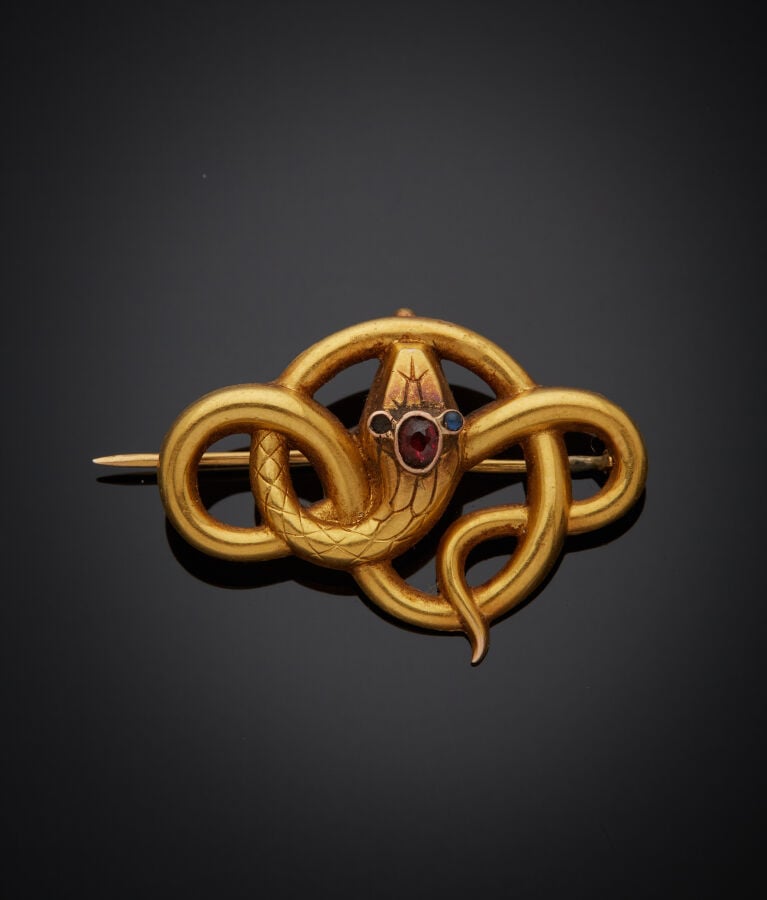 BROCHE "serpent" en or jaune (750‰) ajouré, ciselé, serti de pierres rouges et…