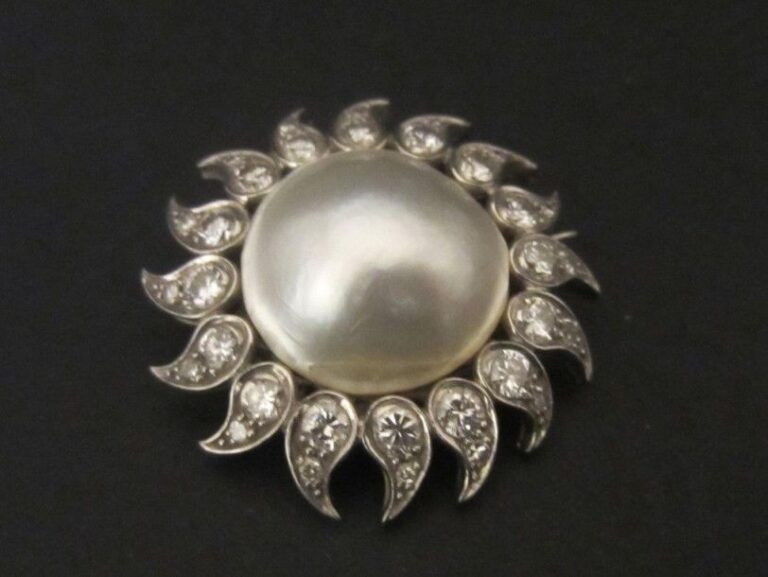 BROCHE «soleil» en platine (850 millièmes) et or gris (750 millièmes) serti d’une perle «Mabé» blanche entourée de diamants taille brillant et 8 8