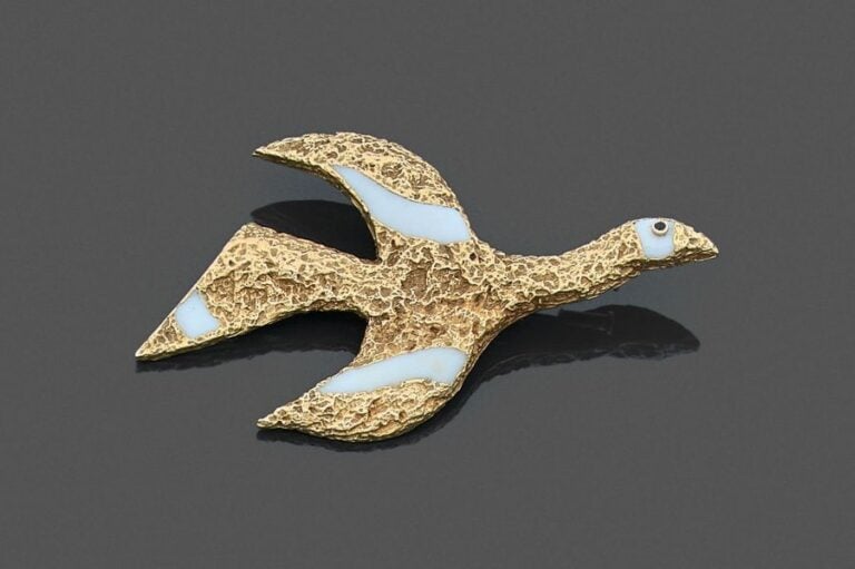 •BROCHE «Tithonos» en or jaune martelé orné d'émail blanc et serti d'un saphir ron