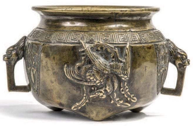 Brûle-parfums en bronze sur trois petits pieds, à décor de deux phénix alternant avec des motifs géométriques, deux anses en forme de têtes de dragons stylisé
