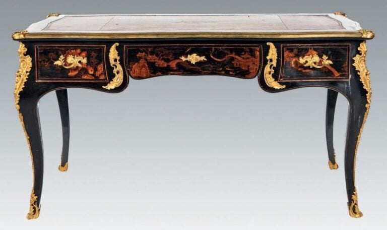 Bureau plat, chantourné, en bois laqué noir et or dans le goût de la Chine, dans des encadrements à filet