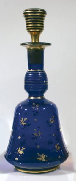Carafe à col étranglé et son bouchon en cristal bleu à décor de filets et de semis d'étoiles et de feuillages dorée