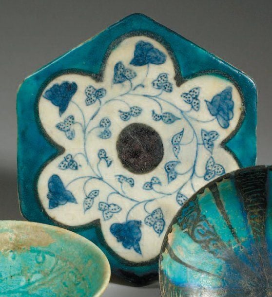 CARREAU AU DÉCOR FLORAL Carreau hexagonal bordé de turquoise et décoré en bleu sur fond blanc de fines tiges feuillagées dans une large fleur polylobé