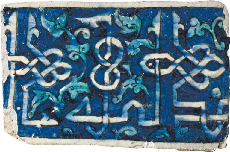 CARREAU ÉPIGRAPHIQUE Frise rectangulaire décorée en relief sur fond bleu d'une belle inscription en coufique géométrique tressé, émaillé de blanc et dont les hampes encadrent des tiges fleuronnées turquois
