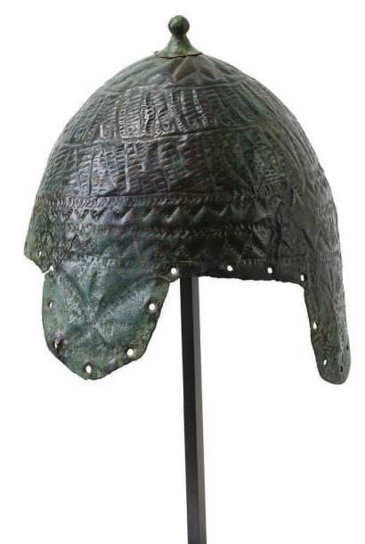 Casque orné de bandes gravées de motifs géométriques dont la présentation est aléatoir