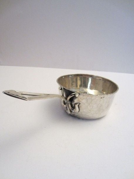 Casserole en argent martelé, le manche ajouré à attache en fleur de ly