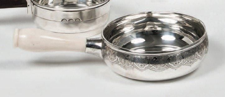 CASSEROLE en argent uni orné d'une frise de coquilles et rinceaux sur fond amati; le manche en ivoir