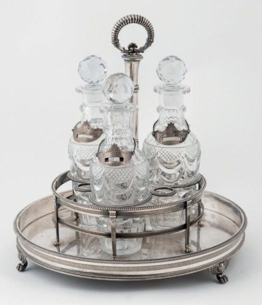 CAVE À LIQUEURS en argent de forme ronde, posant sur quatre pieds griffe surmontés d'ailes déployée