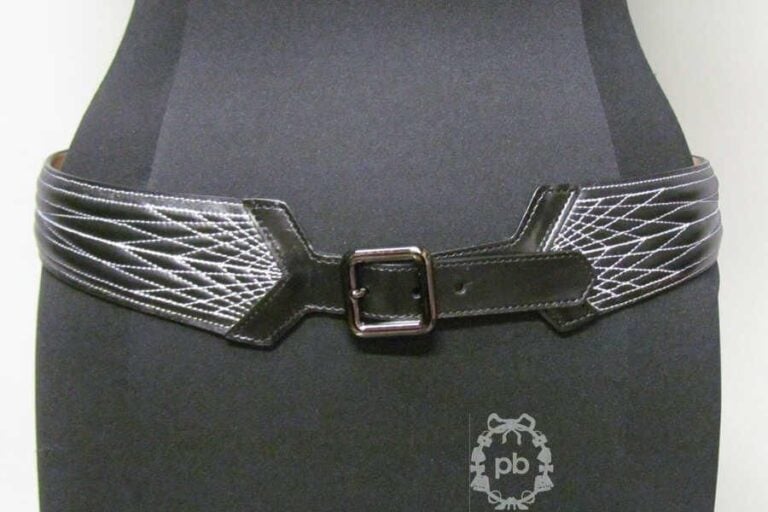 CEINTURE en cuir noir ornée de surpiqûres blanches à effet matelassé et s'attachant à l'aide d'une boucle à ardillon (T85 cm) (excellent état)