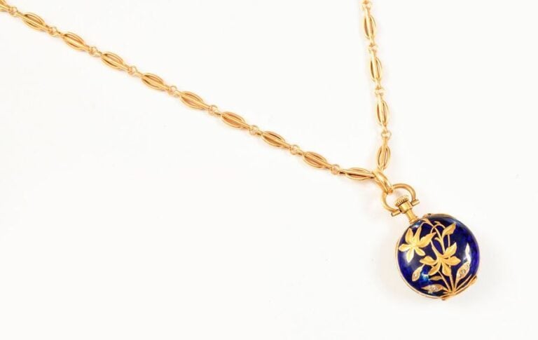 CHAINE à maillons ovales en or jaune soutenant une montre de col ornée d’un motif de fleurs et de feuilles garnies de petits diamants taillés en roses, sur fond d'émail ble