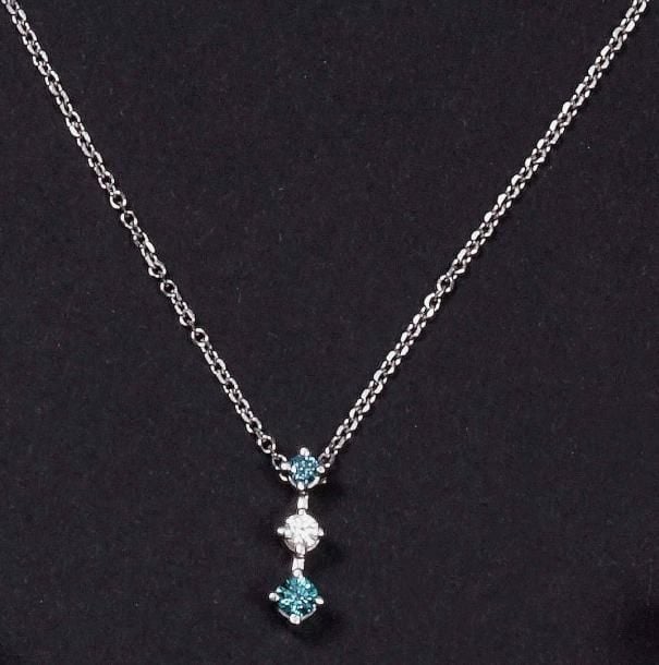 Chaîne en or blanc 14K (585%o) retenant trois diamants de taille brillant, dont deux bleus (traités par irradiation