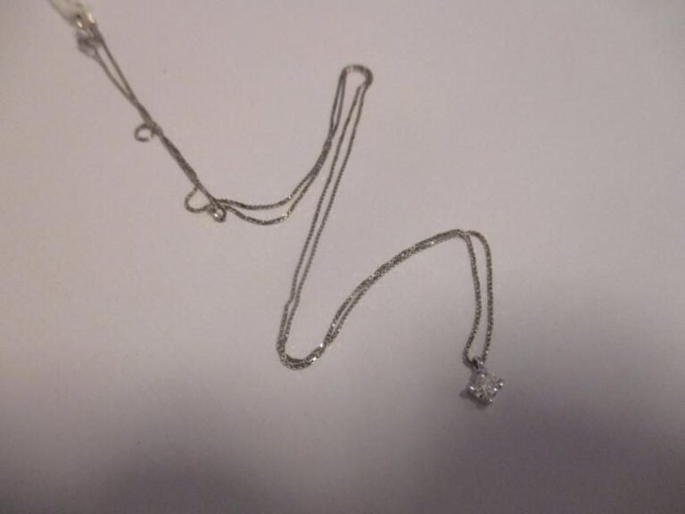 Chaîne en or blanc 18K (750°/00) retenant un pendentif en or blanc 18K (750°/00) serti d'un diamant de taille brillant pesant environ 0,10 cara