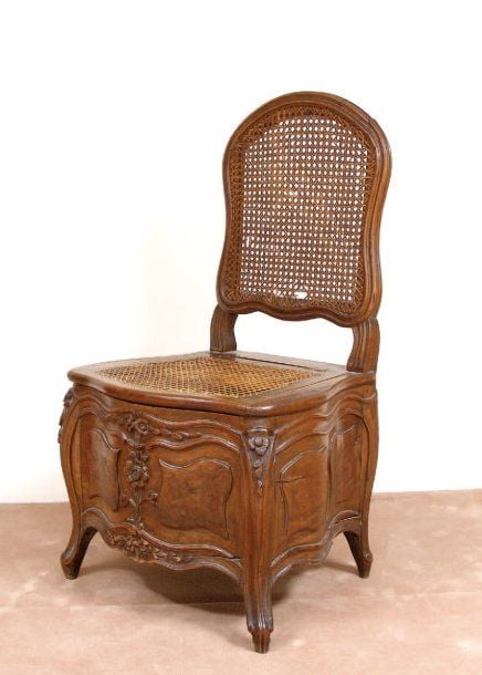 Chaise d'aisance, en noyer mouluré et sculpté à dossier plat, nervur