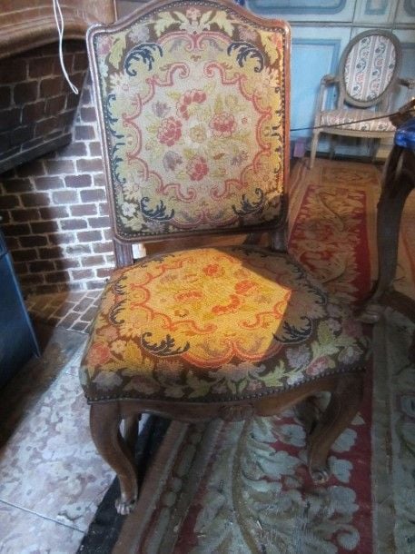 Chaise en bois naturel à piétement entretoisé recouverte de tapisseri