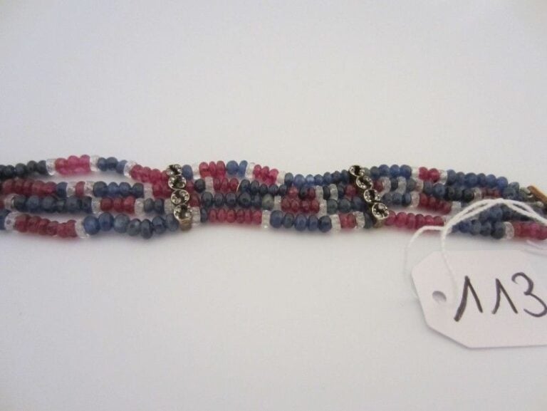 Charmant BRACELET composé de quatre rangs de perles de rubis et saphirs alternées de cristal de roche taill