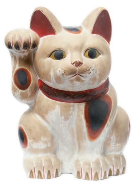 Chat porte-bonheur (manekineko) de porcelaine tendre blanche portant un ruban rouge et levant la patte gauch