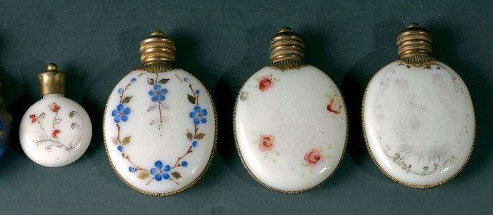Cinq flacons à sels - Trois flacons ovales en opaline blanche, deux à décor de fleurettes, un à décor doré us
