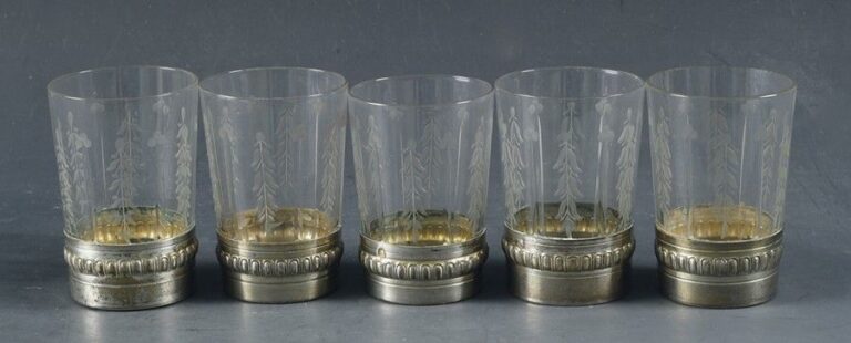 Cinq gobelets à alcool en verre gravé à motif de feuillages stylisés et côtes creuses; monture en argent repouss