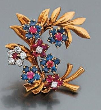 CLIP DE CORSAGE en platine et or jaune à motif de «feuille» rehaussé de sept fleurettes serties de diamants, rubis et saphir