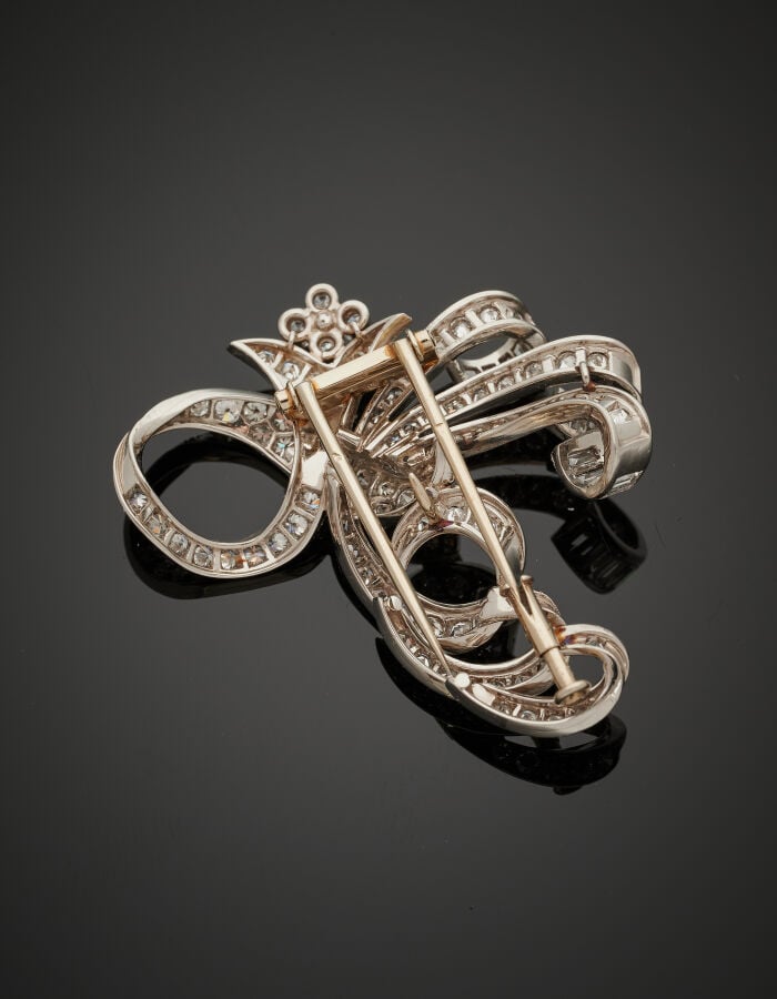 CLIP de CORSAGE "volutes" en platine (950‰) et or gris (750‰) ajouré, pavé de d…