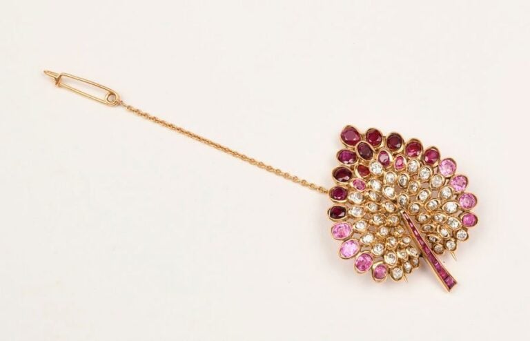 CLIP en or jaune en forme de feuille serti de rubis et de diamants ronds et la tige en ligne de rubi