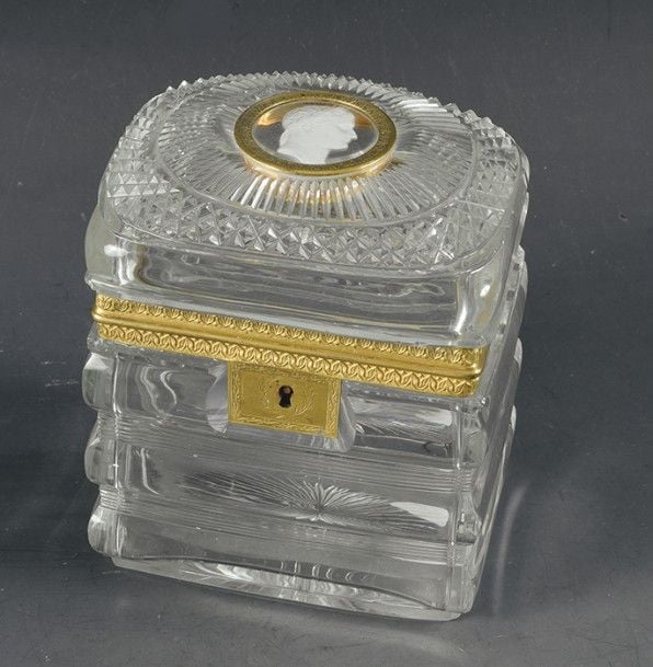 Coffret à section rectangulaire en cristal taillé à larges côtes horizontales séparées par des rubans de filets; le couvercle bombé, taillé à large côte horizontale et pointes de diamant, est orné d'un cristallo- cérame, signé Andrieu, représentant le profil droit de Napoléon 1er d'après la médaille gravée en 1805 par Bernard Andrie