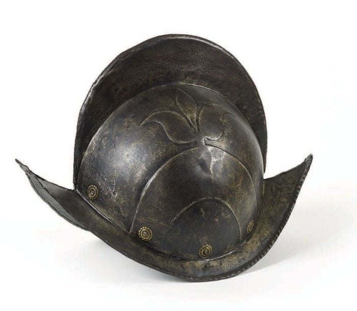 COIFFURES Morion de Garde civique germanique, en fer forgé, en deux parties, à décor repoussé d'une fleur de lys, garni de rivets en laito
