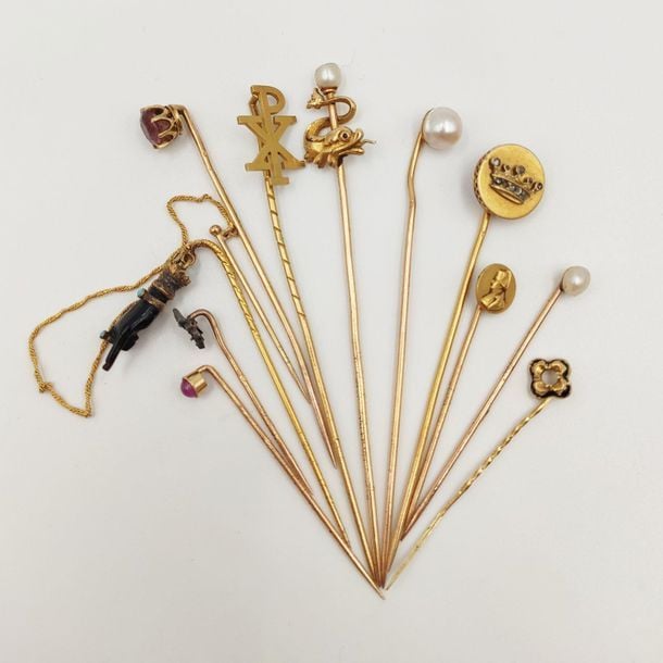 •Collection de onze EPINGLES à CRAVATES diverses (couronne, dauphin, monogramme, trèfle, fleur de lys, Napoléo