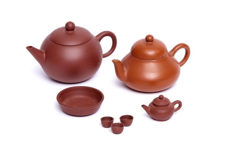 Collection de trois petites théières chinoises marron, de style Yixing: Une toute petite théière de Shantou (Swatow), avec trois petites tasses sur une assiett