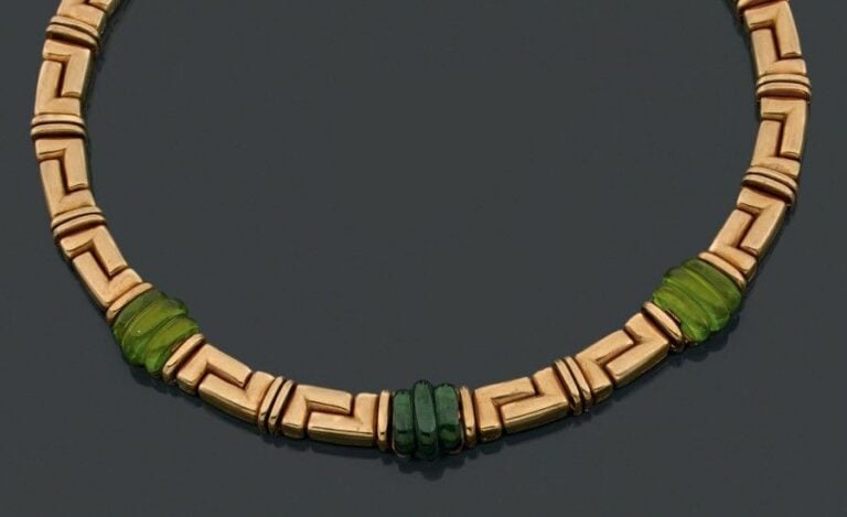 COLLIER articulé en or jaune (750 millièmes) godronné à maillons géométriques orné de trois péridots godronné