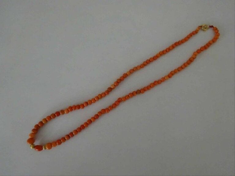 COLLIER AUX PERLES DE CORAIL ROUGE ORANGE Chine Epoque XXe siècle Fermoir métal doré perle centrale oblongue flanquée de deux boules godronnées en également en métal dor