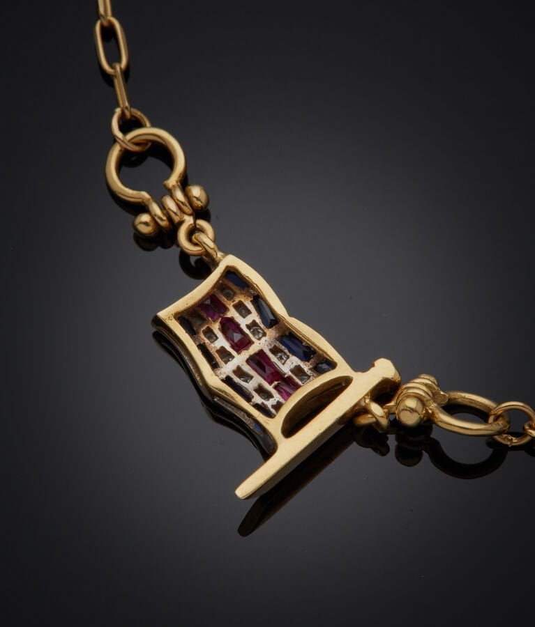 COLLIER chaînette en or jaune (750‰) retenant un pavillon serti de saphirs, rub…
