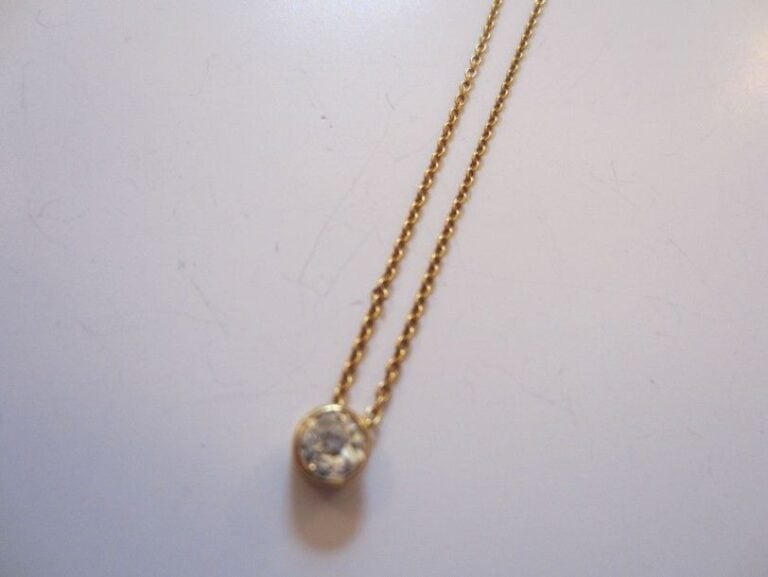 COLLIER CHAINETTE en or jaune retenant un diamant en serti clo