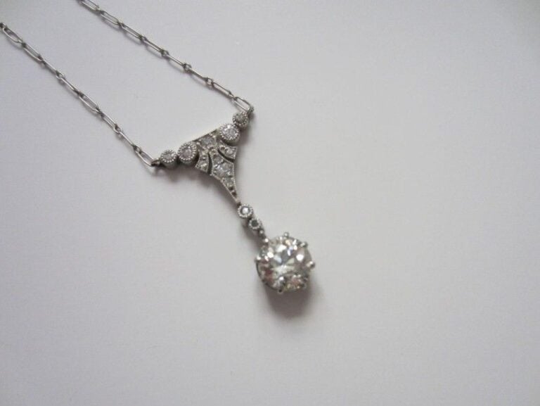 COLLIER chaînette en platine retenant un motif géométrique triangulaire serti de diamants et terminé par un diamant taille ancienne plus importan
