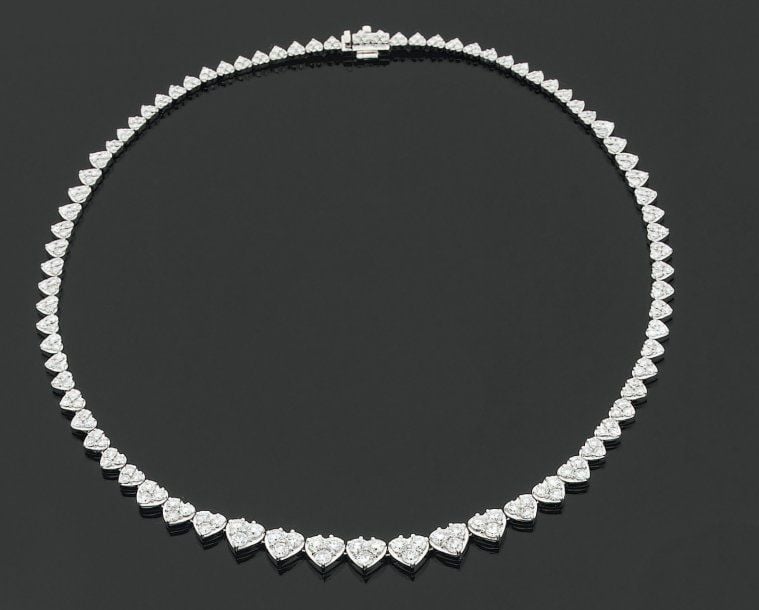 COLLIER « coeurs » en or gris articulé, chaque motif serti de trois diamants de taille brillant, en chut