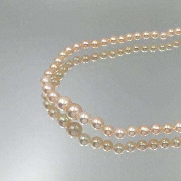 COLLIER composé d'un rang de 107 perles fines rondes en chute, de couleur blanc crèm