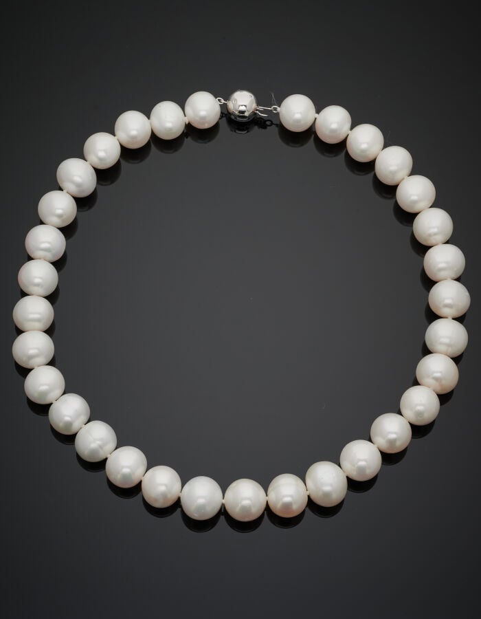 COLLIER composé d'un rang de 32 perles de culture blanches. Fermoir boule en or…