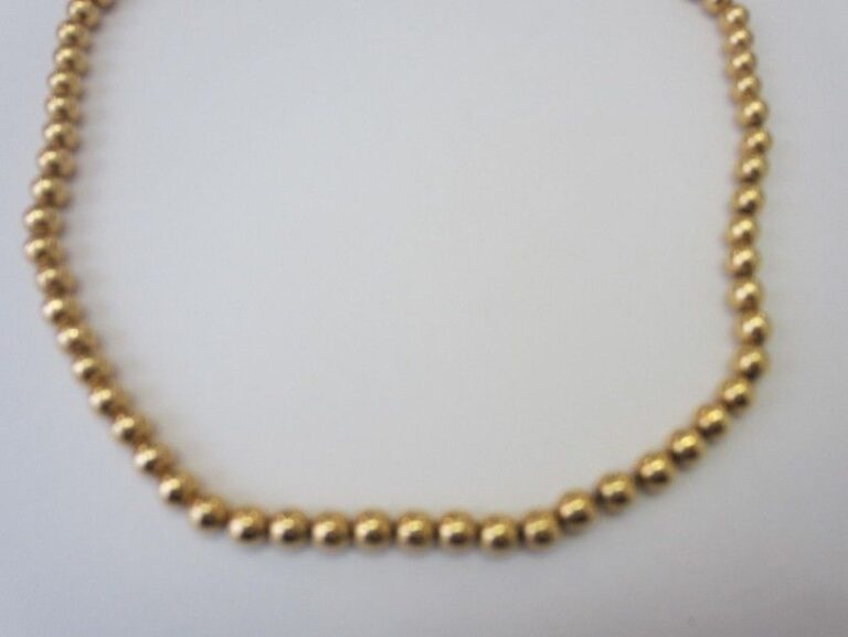 COLLIER composé d'une chainette retenant une succession de perles d'or jaune (750 millièmes