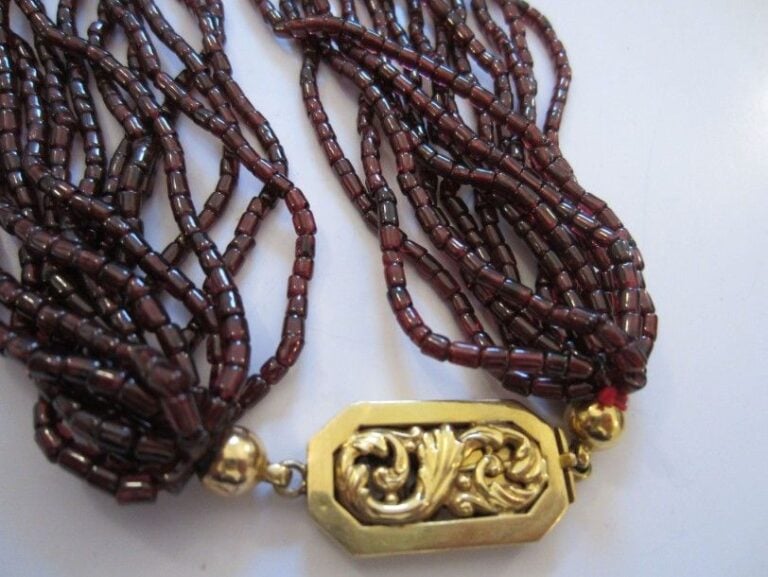 COLLIER composé de 14 rangs de perles cylindriques de grenat