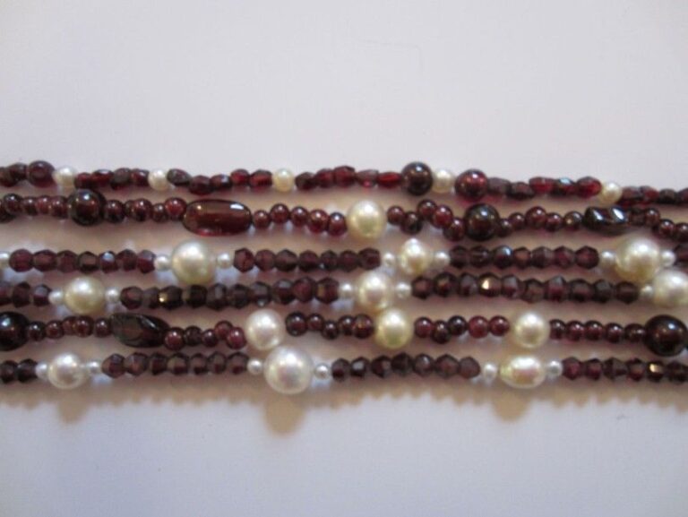 COLLIER composé de 6 rangs de perles de grenats dont certaines facettées alternées de perles de culture blanches de différentes taille
