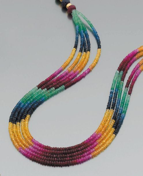 COLLIER composé de cinq rangs de perles de saphirs bleus et jaunes, de rubis et émeraude