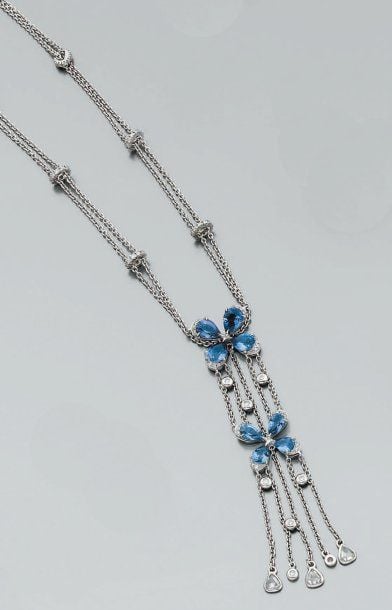 COLLIER composé de deux chaînettes en or gris ornées de six coulants sertis de diamants, retenant un double motif « fleurettes » serti de saphirs de forme poire et de diamants de taille brillan