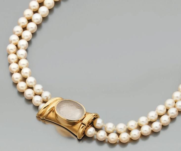 COLLIER composé de deux rangs de perles de culture blanches et d'un important fermoir en or jaune godronné serti d'un camée en cristal de roche représentant un «profil d'homme portant une couronne de laurier